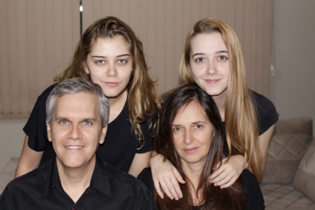Portrait of a family, husband and wife sit and two grown daughters stand behind them